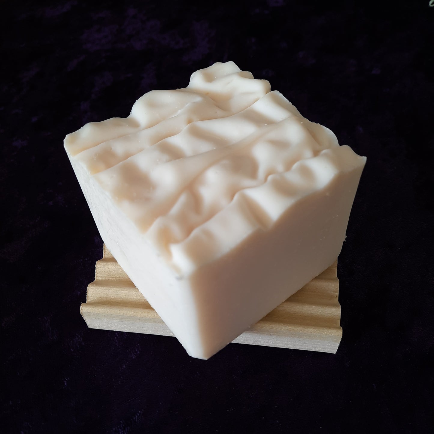 handcrafted vegan soap bar organic oils
on wood soap dish
with moon background spooky dark apothecary style
in bathroom on tile