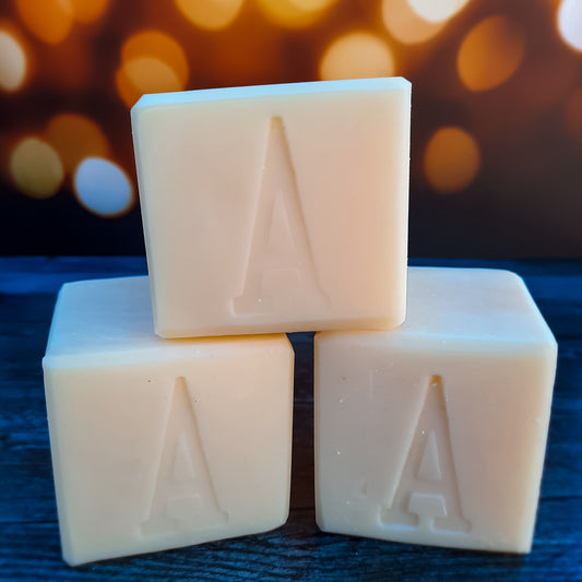 handcrafted vegan soap bar organic oils
on wood soap dish
with moon background spooky dark apothecary style
in bathroom on tile