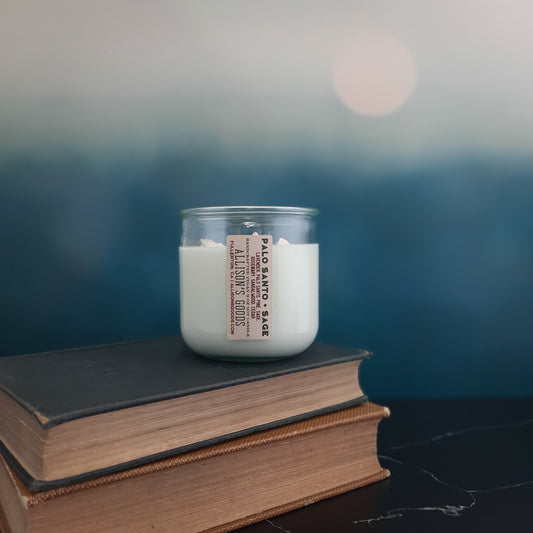 candle on stack of antique books and moon