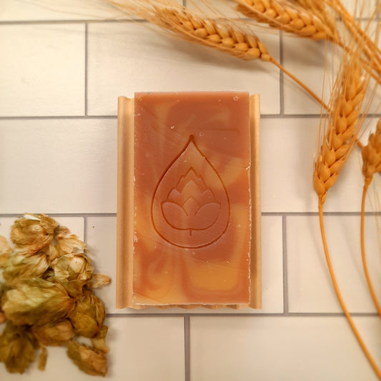 handcrafted vegan soap bar organic oils
on wood soap dish
with moon background spooky dark apothecary style
in bathroom on tile