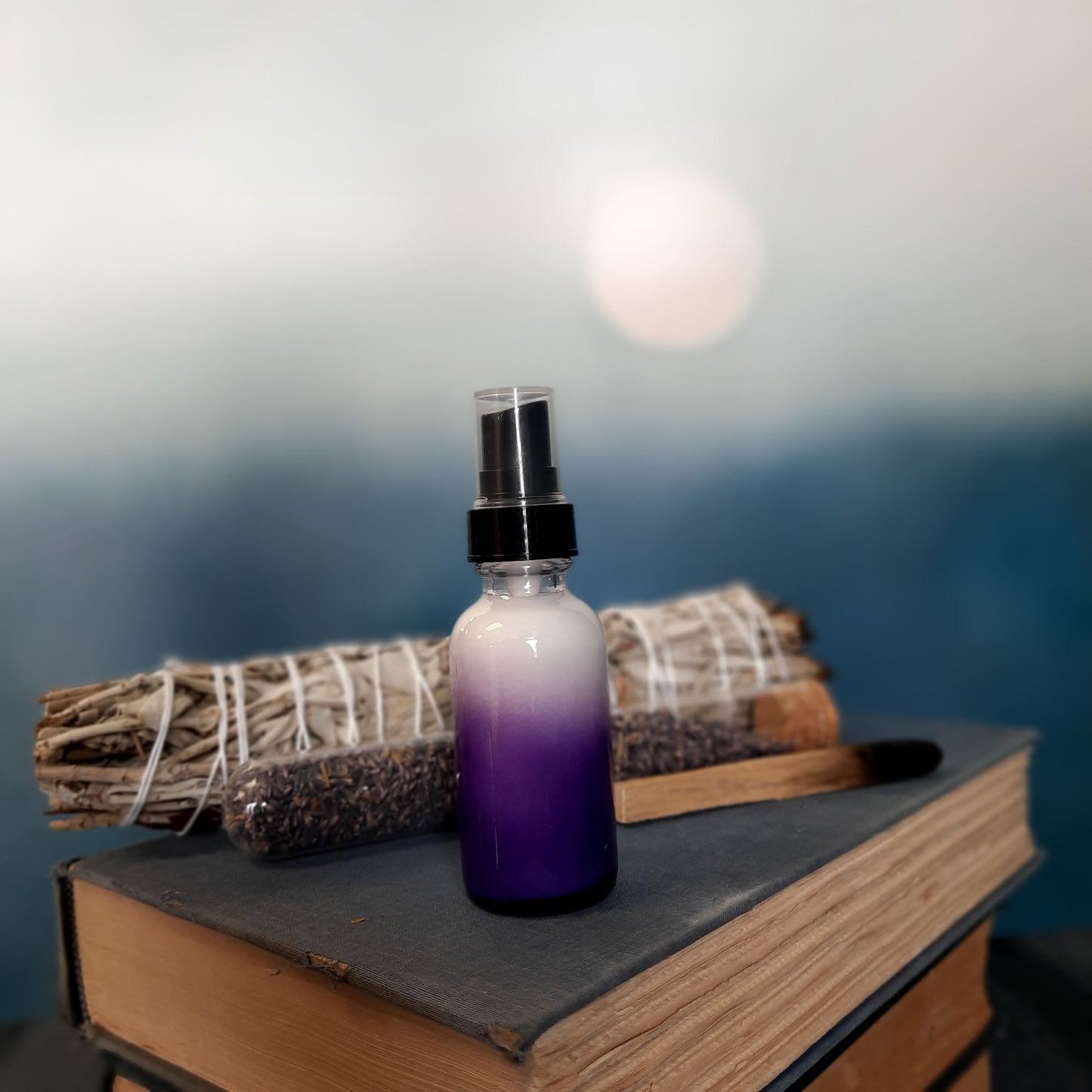 purple glass bottle on stack of vintage books with green plants
