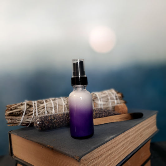 purple glass bottle on stack of vintage books with green plants