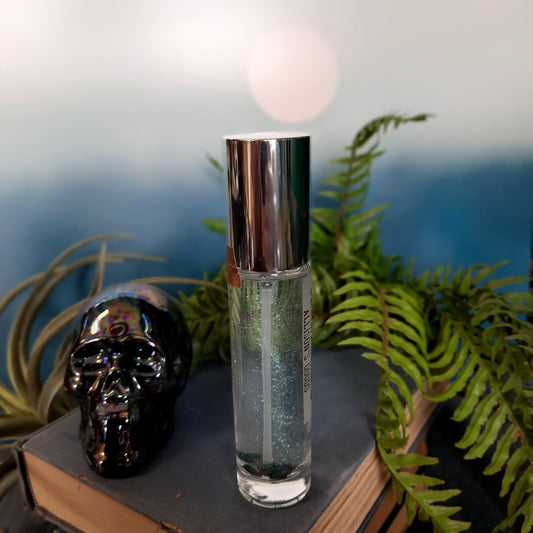 clear glass spray bottle with silver lid on books