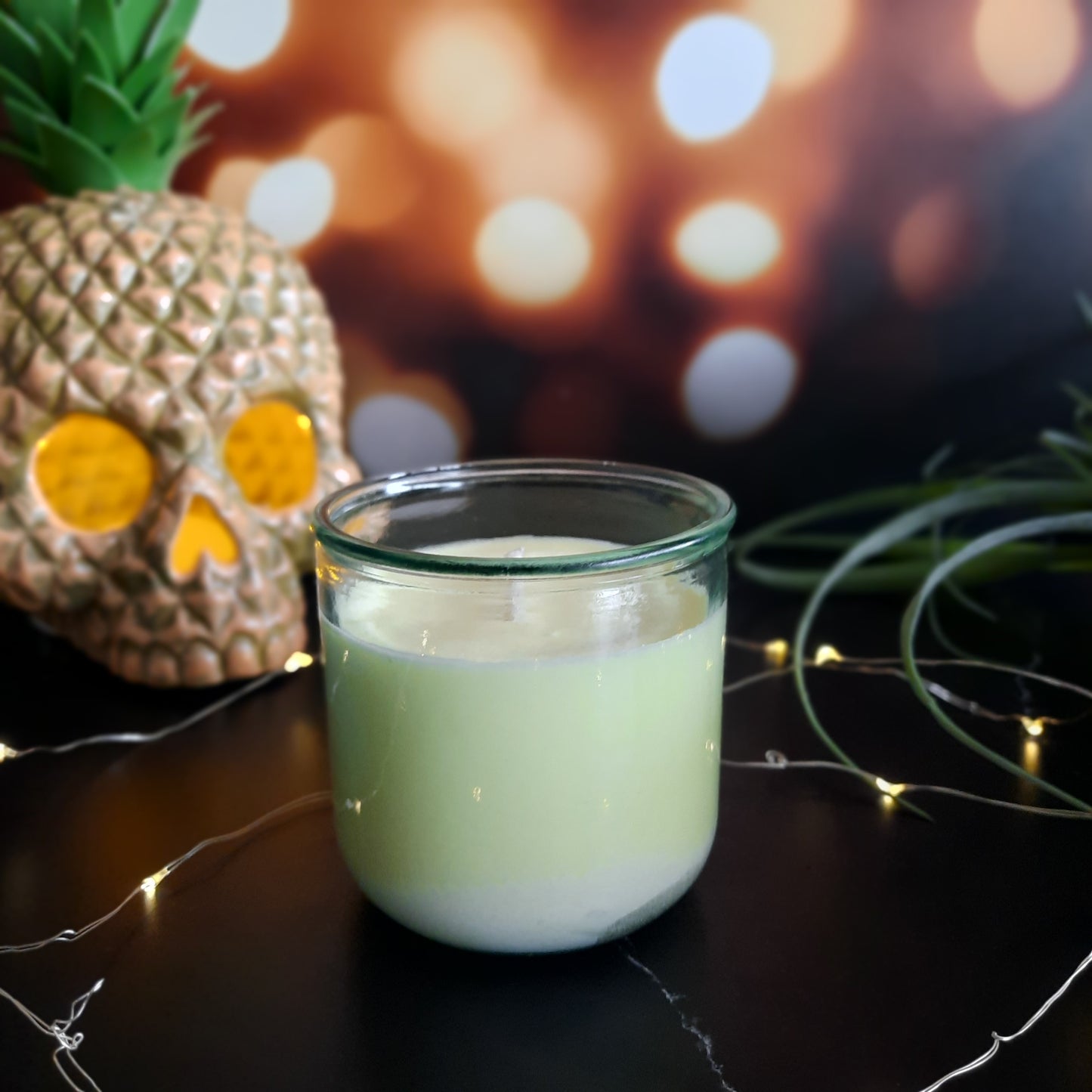 picture of yellow candle with twinkle lights and pineapple skull