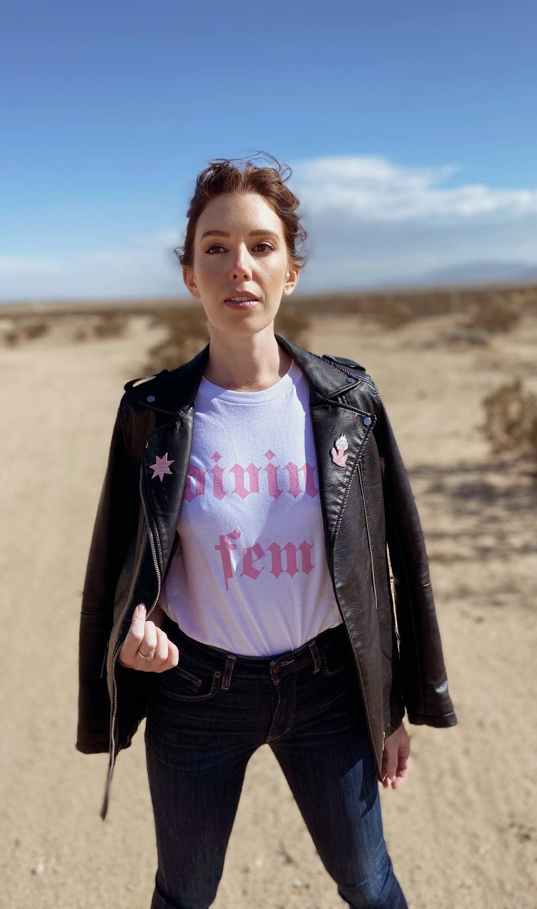 woman in desert with black jacket and pin