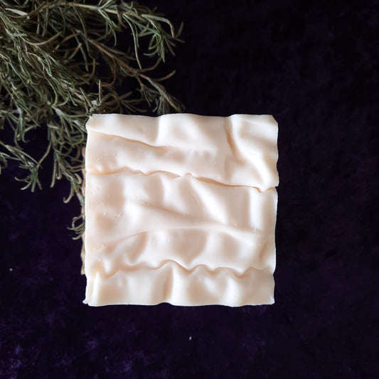 handcrafted vegan soap bar organic oils
on wood soap dish
with moon background spooky dark apothecary style
in bathroom on tile