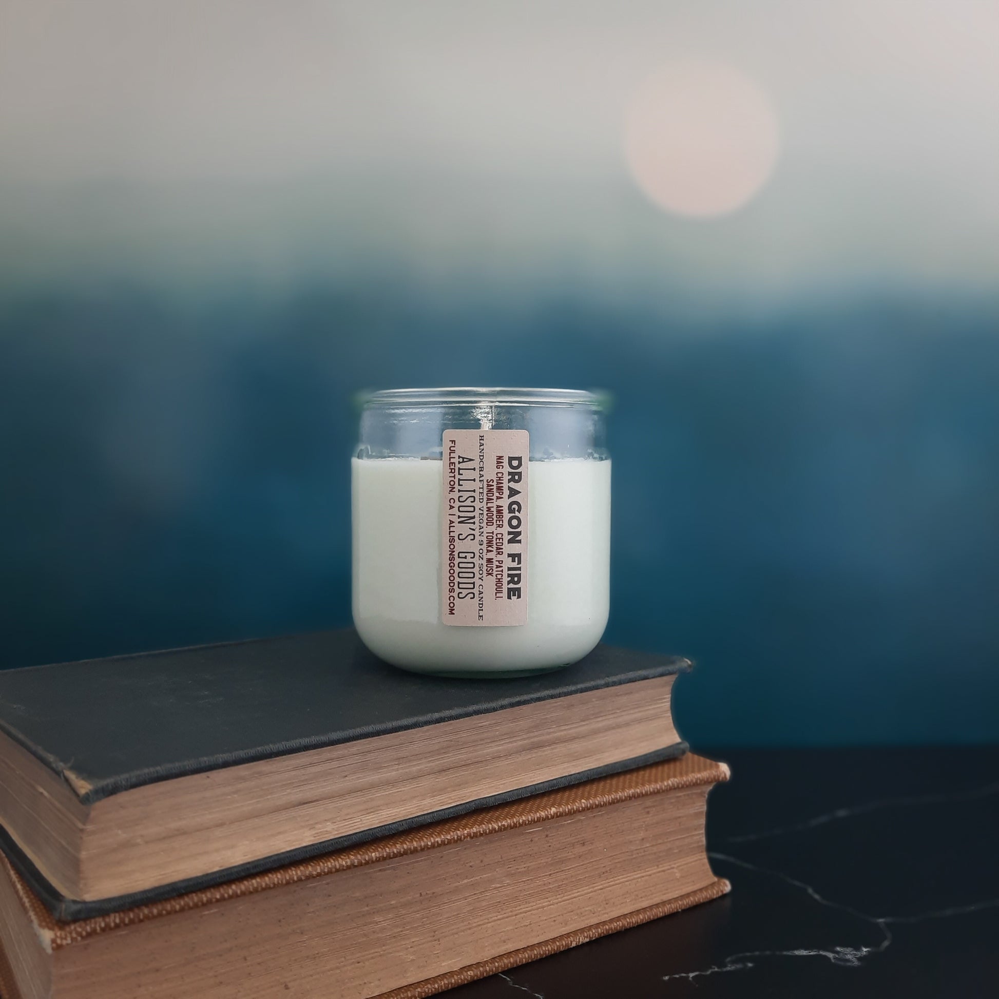 sustainable vegan candle on antique books and blue moonrise
