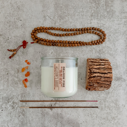 flat lay of sustainable vegan candle jar on cement with incense wood and sandalwood beads