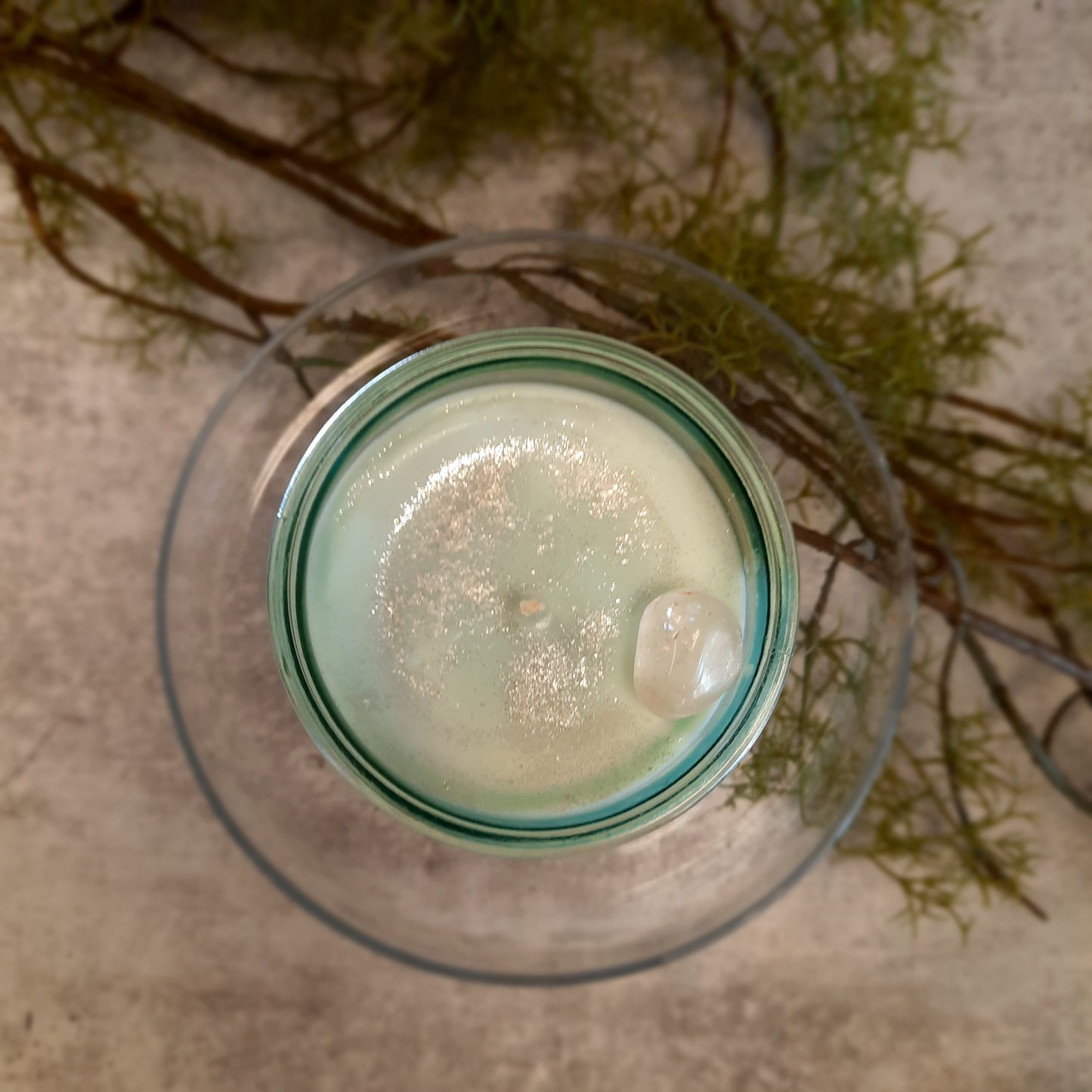 flat lay of sustainable vegan candle jar on cement with moss
