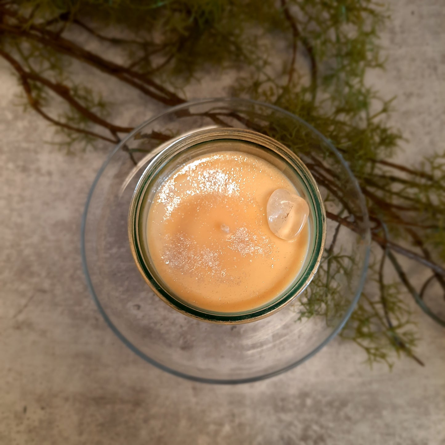 flat lay of sustainable vegan candle jar on cement with moss