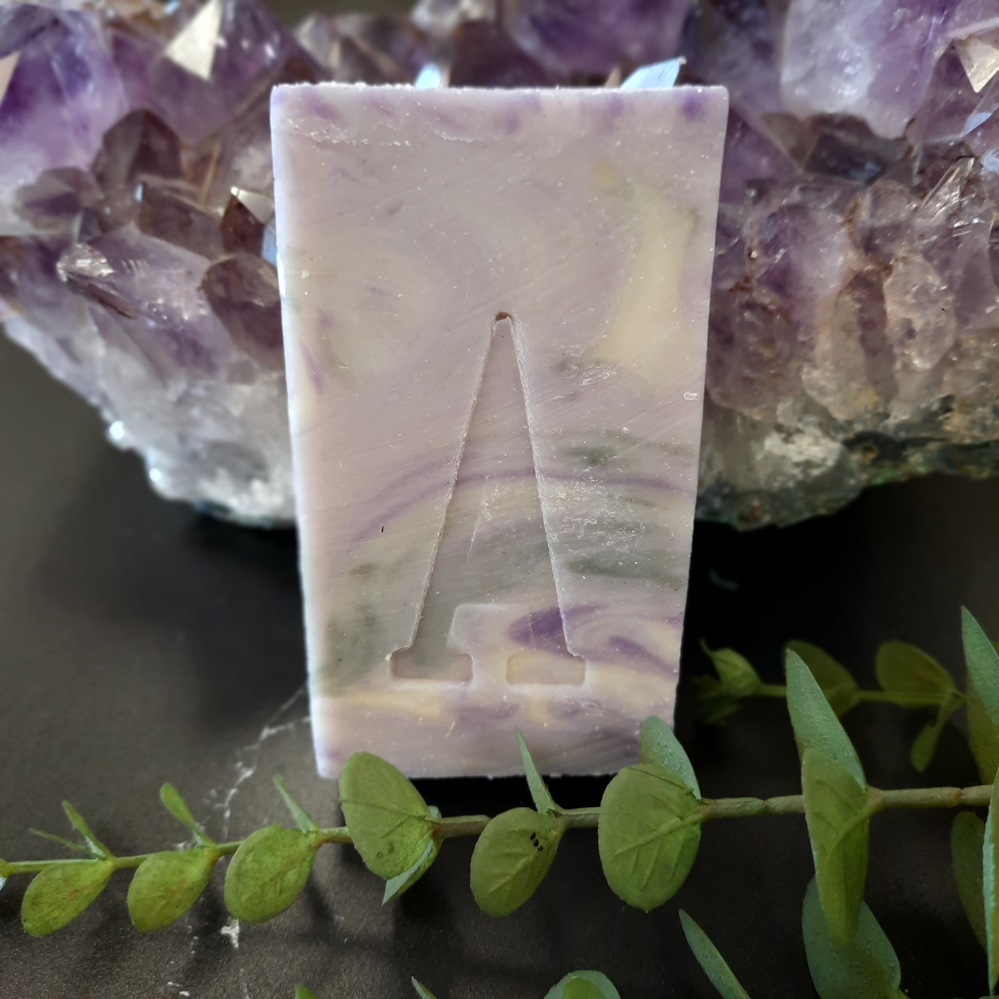 handcrafted vegan soap bar organic oils
on wood soap dish
with moon background spooky dark apothecary style
in bathroom on tile