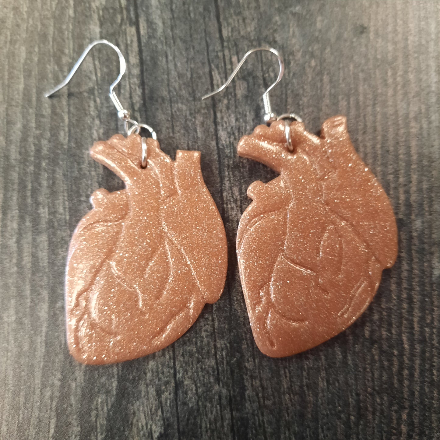rose gold heart earrings flat on wood