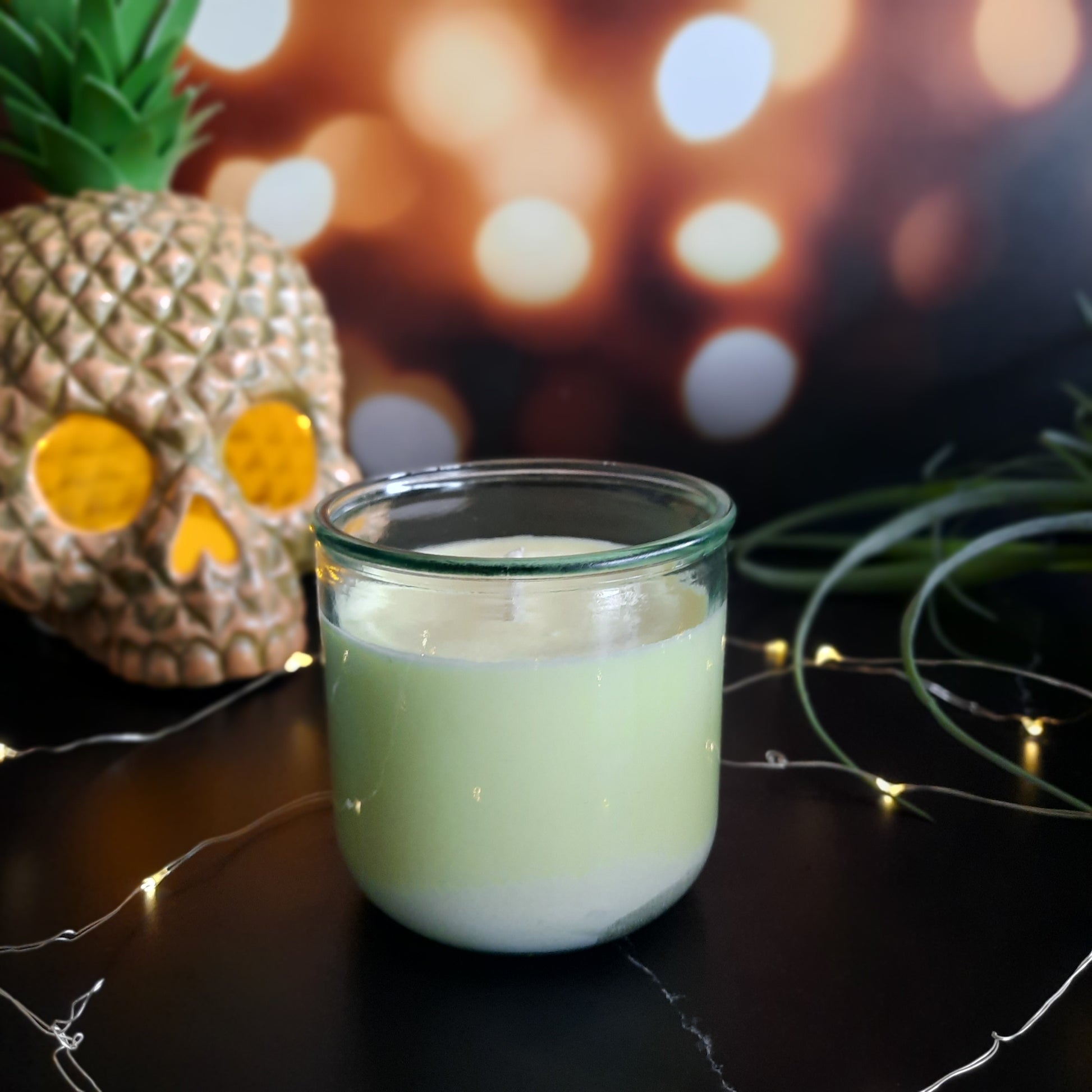picture of yellow candle with twinkle lights and pineapple skull